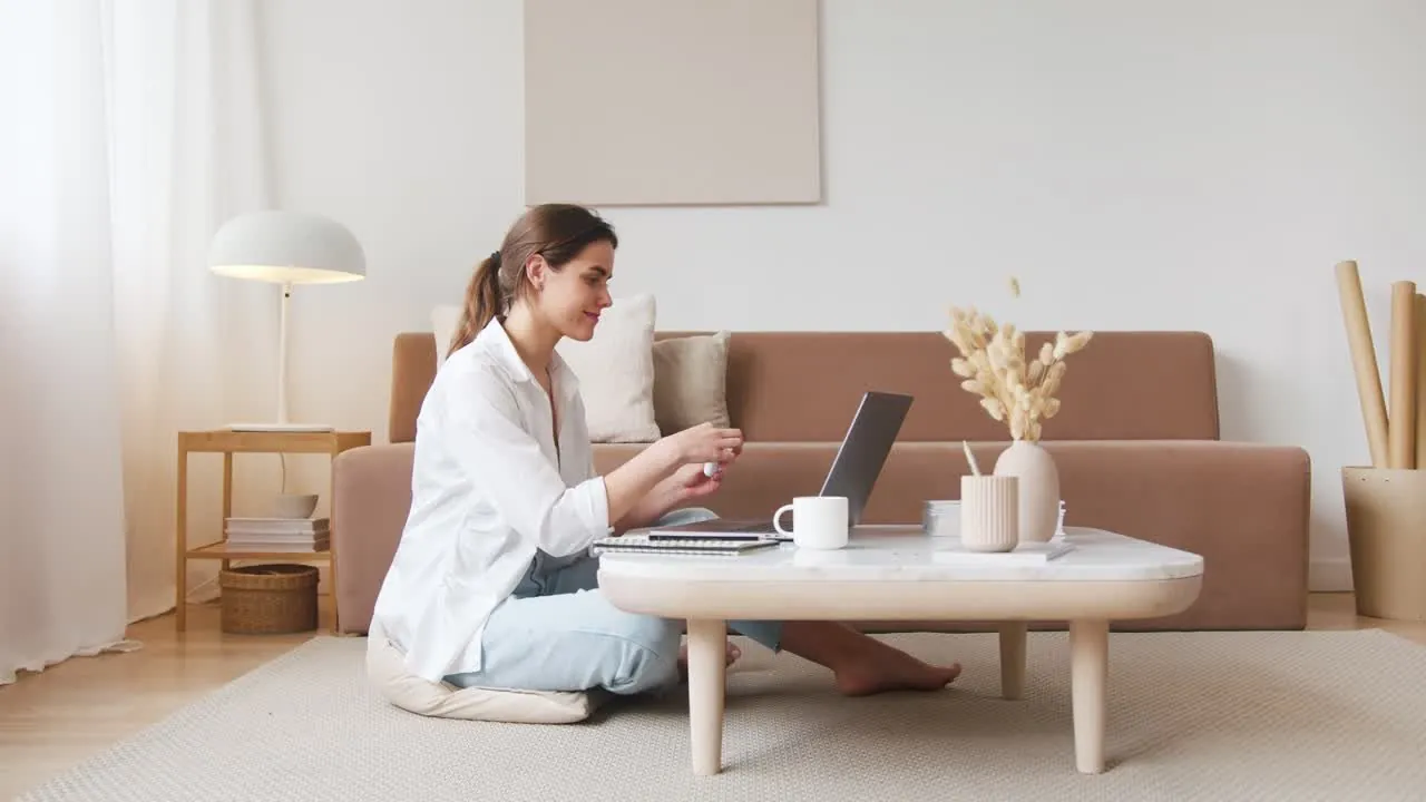 Auckland home buyer working on her laptop in her living room after arranging her home loan with The Mortgage Advisers, NZ Mortgage Awards Excellence Awardee three years running