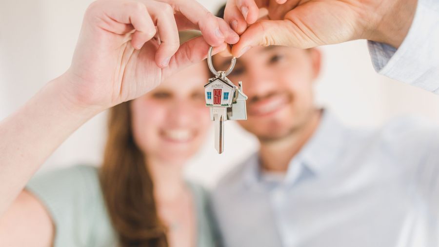 Young couple holding the keys to their first home
